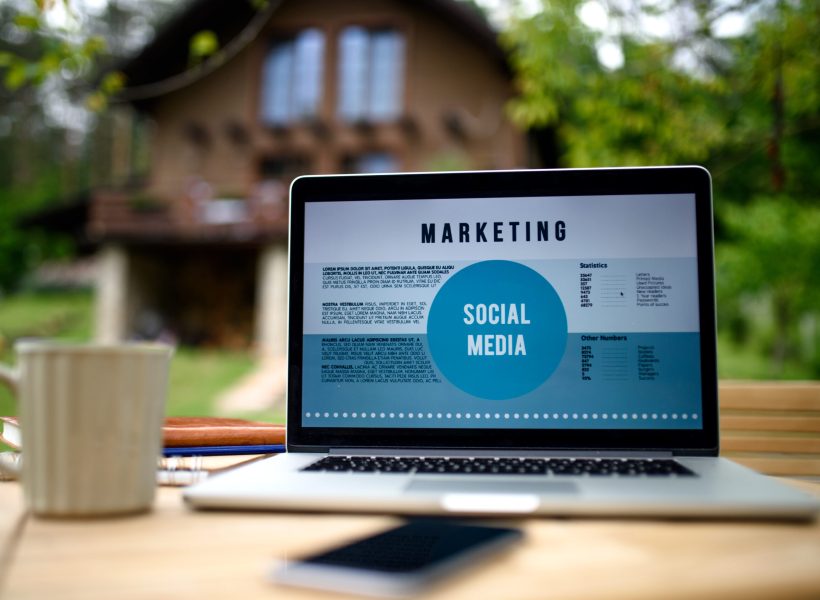 Laptop and coffee on desk outdoors in garden, home office concept.